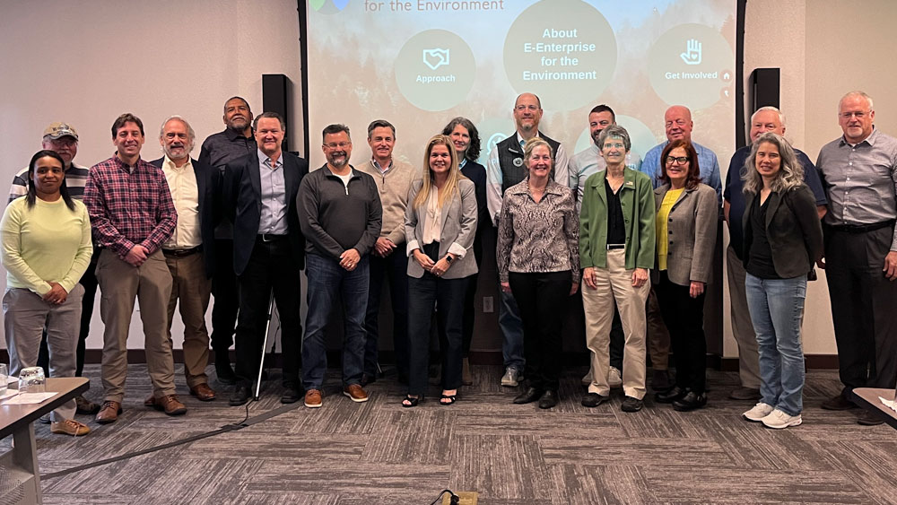EELC and other E-Enterprise members standing in front of a screen.