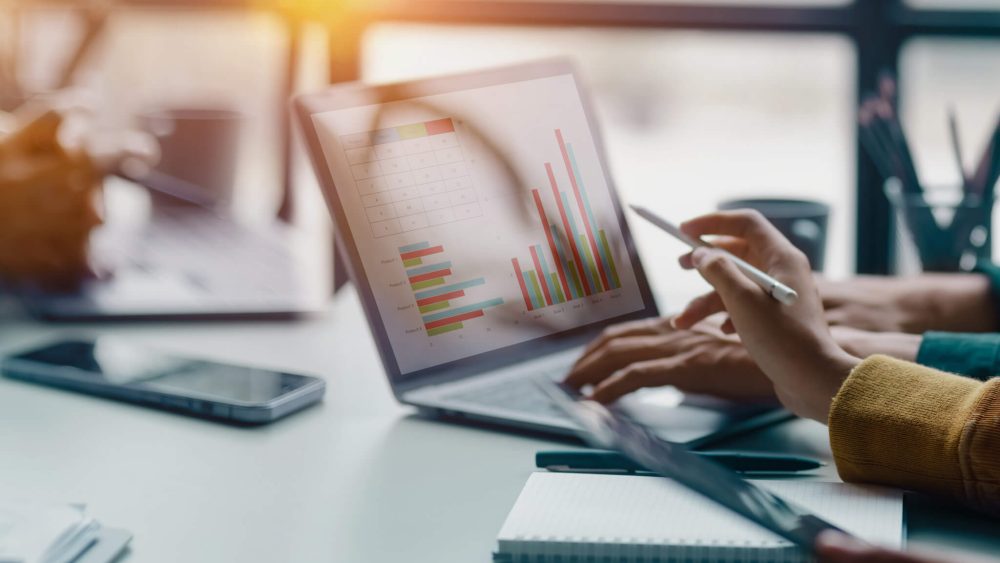 People looking at graphs and charts on a laptop screen