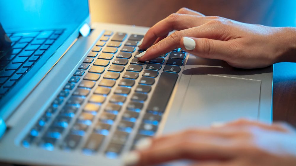 Close up of hands typing on laptop